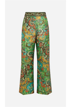 A pair of wide-leg pants featuring a vibrant, multicolored paisley pattern with green, yellow, orange, and blue tones, set against a light grey background.