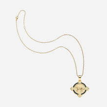 Gold necklace with a pendant with a horse on it, on a light grey background