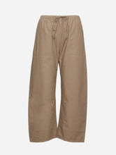 A pair of wide-leg pants in a light tan color, featuring an elastic waistband with a drawstring, shown against a plain light gray background.