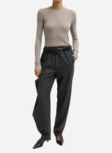 Person wearing black high-waisted flannel drape pants on a light grey background