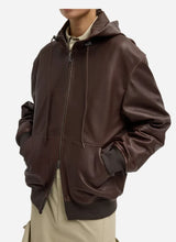 Brown leather zip up jacket worn by a person on a light grey background