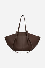 Large brown leather handbag on a light gray background