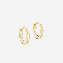 gold hoop earrings on a light grey background