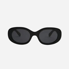 Black round frame sunglasses with black lenses on a light grey background