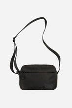 a rectangular black zip up bag with a long shoulder strap