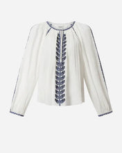 White blouse with blue embroidery on a light grey background