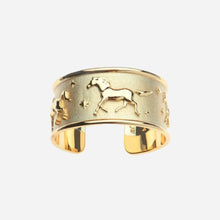 Gold cuff bracelet with horse design on a light grey background
