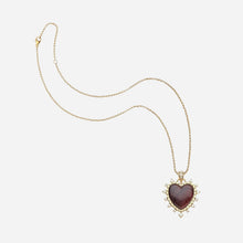 Heart-shaped pendant necklace with gold chain on a white background