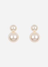 Pair of pearl earrings on a light grey background