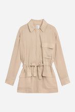 Beige drawstring jacket with a collar and front pockets on a light gray background