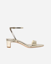 mid heel gold sandal with a thin ankle strap on a white background