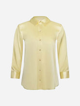 Light yellow button up dress shirt with long sleeves on a light grey background
