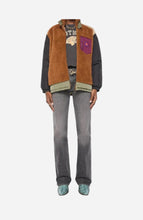 A model is shown from the neck down wearing a fleece vest with brown sherpa against a light grey background.