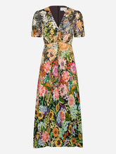 A short-sleeve V-neck maxi dress with an all-over  floral print in green, pink, orange, yellow, and purple,shown against a light grey background.