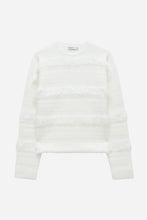 White sweater with ruffles on a light grey background