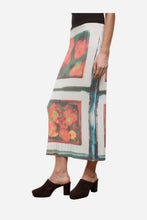 A white skirt with colorful block images of flowers on a light grey background