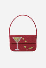 A red beaded shoulder bag with a flap closure featuring a martini glass and olives embellished with beads, on a light grey background.