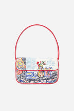 A small structured shoulder bag with a red leather strap and trim, featuring a white flap decorated with colorful embroidered motifs including a teacup and flowers, shown on a light grey background.