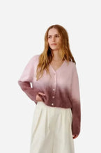 A pink and mauve ombre knit cardigan with white buttons against a solid light gray background.